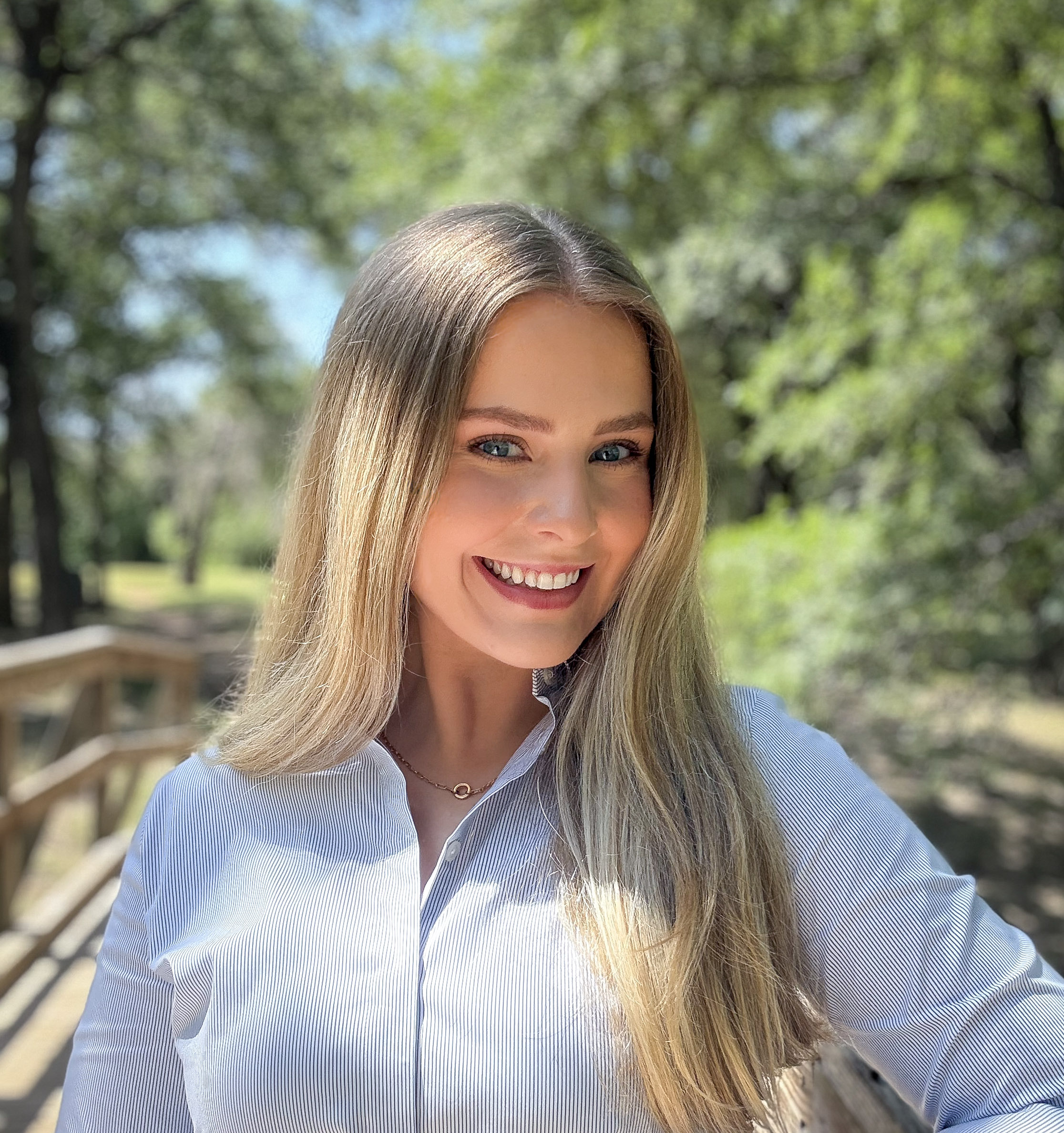 Caitlyn Hansen smiling outdoors in a professional headshot.