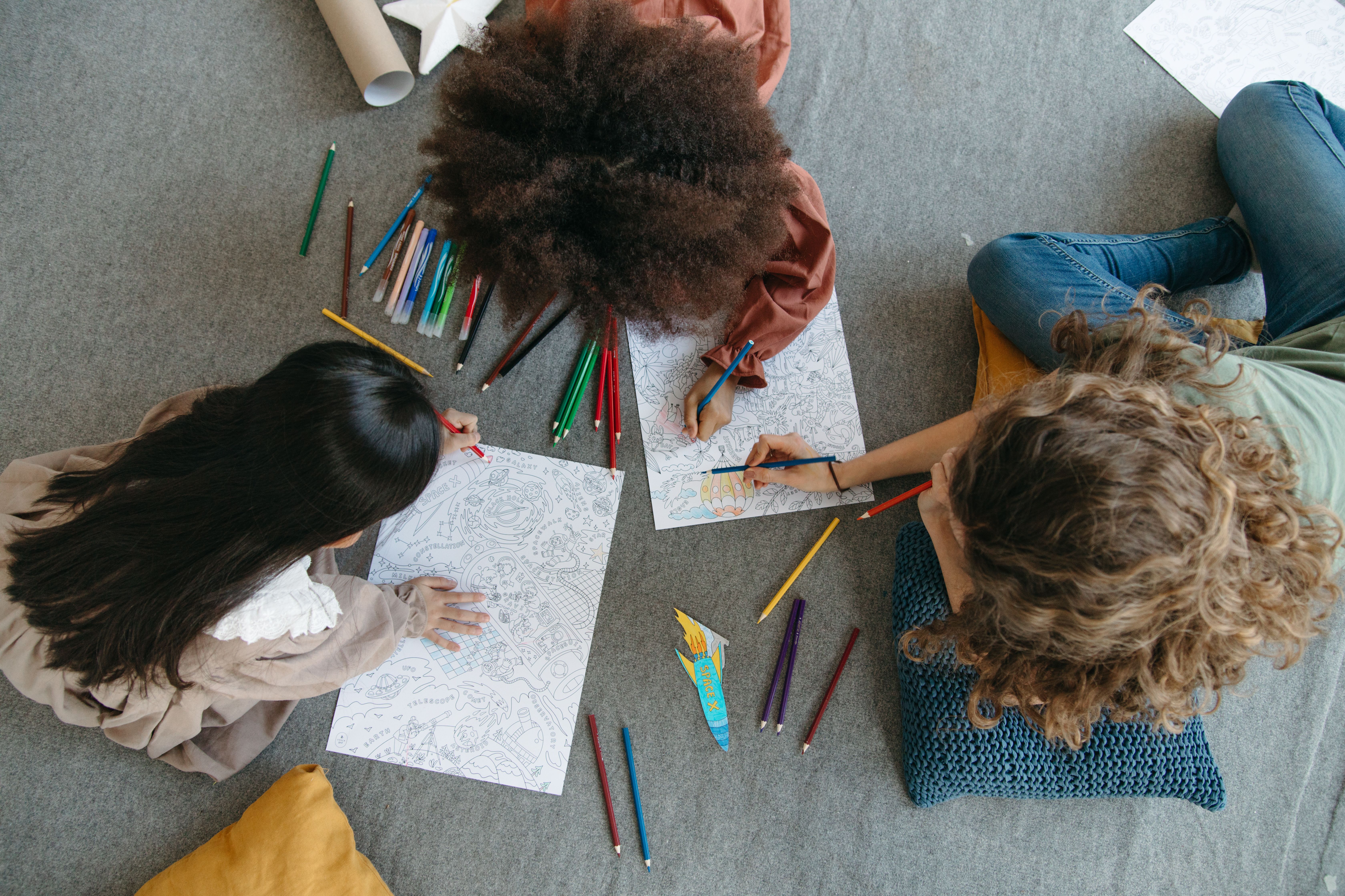 Children and teens drawing together during a supportive, engaging therapy-style activity.